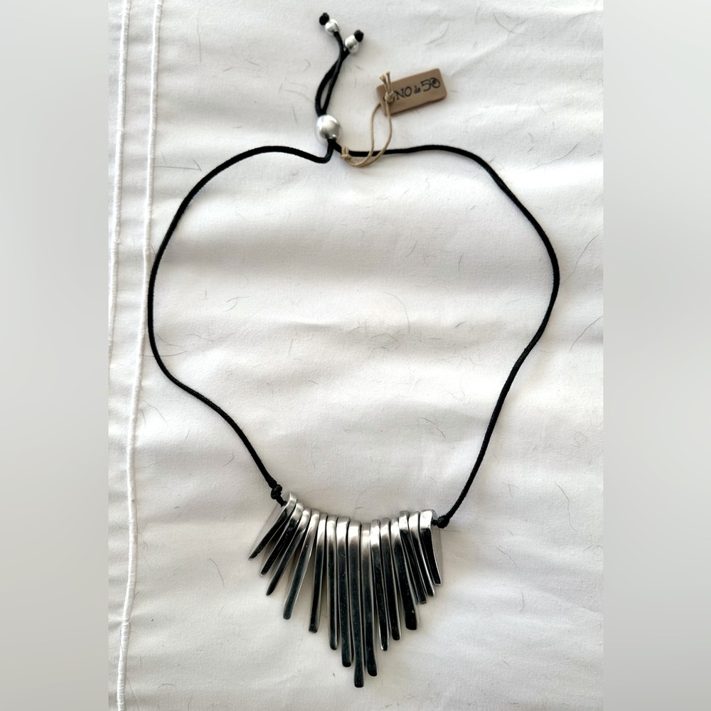 Uno de 50 Necklace, new with tags. Adjustable black cord, silver metal.